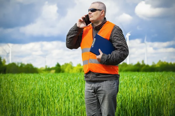 Agricultor con smartphone en el campo de cereales verde —  Fotos de Stock