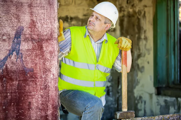 Travailleur de la construction avec marteau près du mur — Photo