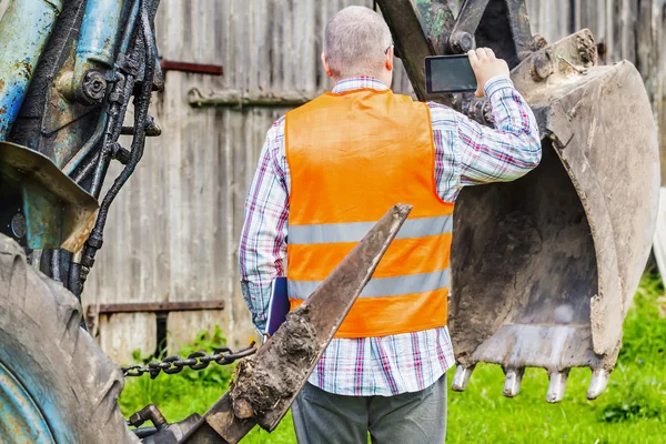 Worker filmed tractor's excavator scoop — Stock Photo, Image