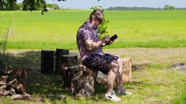 Tablet Pc ağacının altında yaz aylarında kullanan adam 