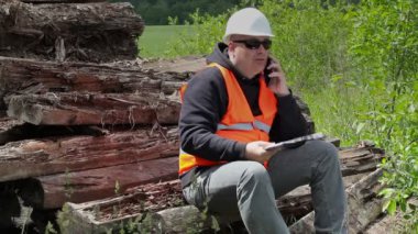 Oturma ve akıllı telefonda konuşurken sinirli işçi