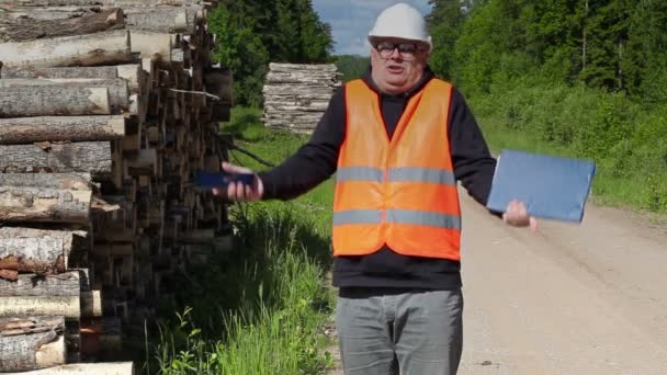 Wütender Holzfäller spricht in der Nähe von Holzstapel — Stockvideo