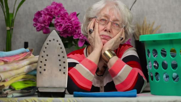 Gelangweilte ältere Frau beginnt zu bügeln — Stockvideo