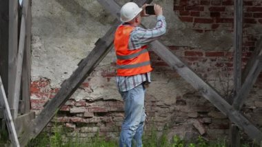 İnşaat işçisi Tablet Pc ahşap iskele yakınındaki fotoğraf çekmek 