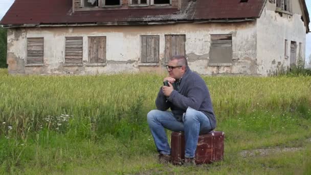 Man sitter på resväska och gråter — Stockvideo