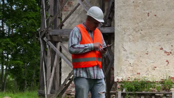 Trabalhador da construção pensando e usando tablet PC — Vídeo de Stock