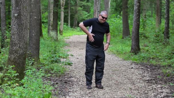 Loper met epigastrische pijn Bel op telefoon in bos — Stockvideo