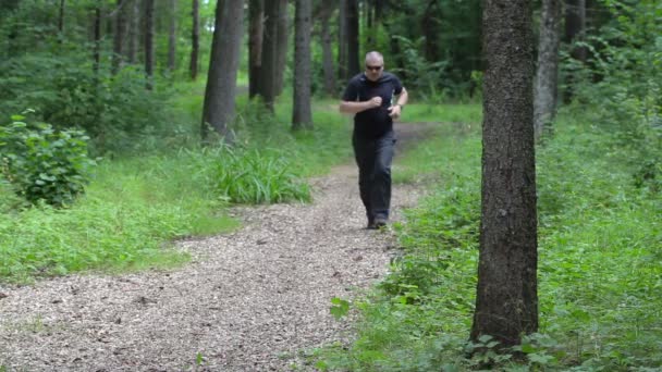 Corredor cansado na trilha da floresta perto da árvore — Vídeo de Stock