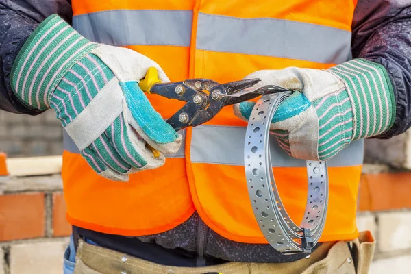 Construction worker with metal Cutting shears and mounting tape — Stock Photo, Image