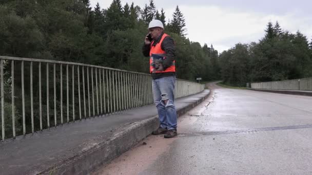 Werknemer praten op mobiele telefoon op de brug — Stockvideo