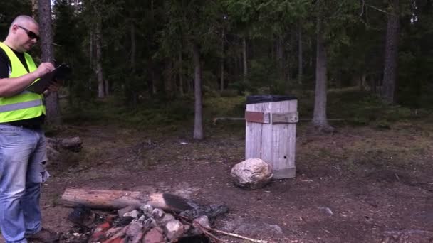 Inspetor ambiental escrevendo na floresta em 4K — Vídeo de Stock