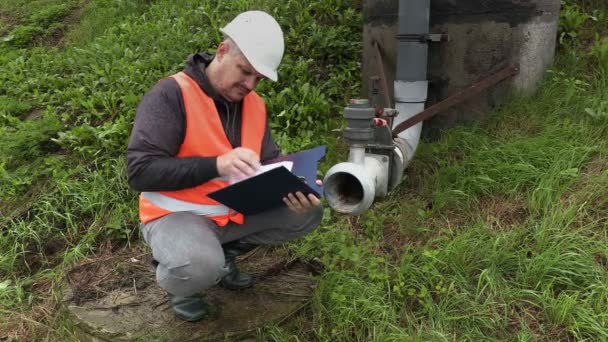 Ingenieur met documentatie in de buurt van de vuile pijp in 4k — Stockvideo