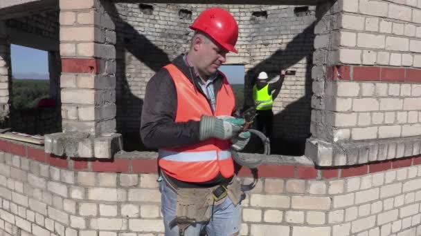 Byggnadsarbetare med metall kapning saxar och montering tejp — Stockvideo