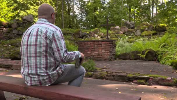 Man leest de Bijbel in buiten kerk — Stockvideo