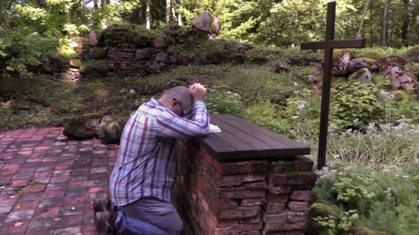 Man kneeling at the altar in outdoor church — Stock Video