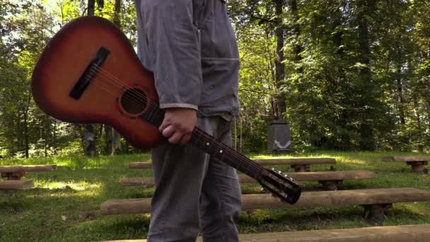 Mannen med gitarr i park — Stockvideo