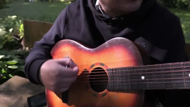 Uomo seduto e suonare la chitarra — Video Stock