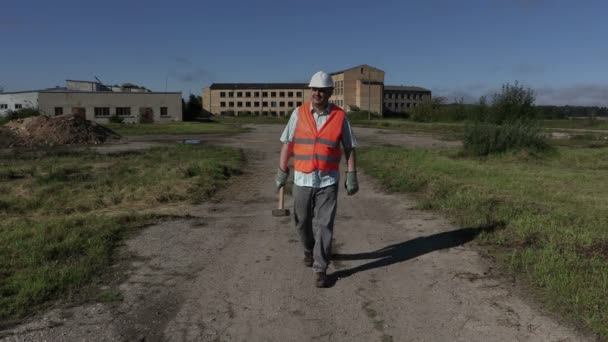 Worker comes and take hammer on the shoulder — Stock Video