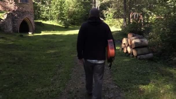 Man met de gitaar in de hand weglopen — Stockvideo