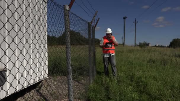 Ingeniero con lectura de teléfonos inteligentes y caminar — Vídeos de Stock