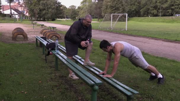 Genç atlet push up eğitmen Stadı yakınlarında — Stok video