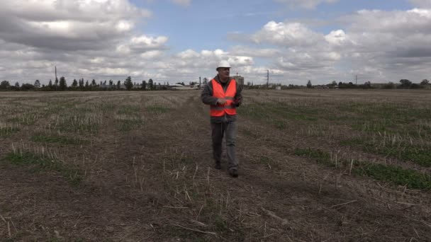 Ingenieur foto's nemen op het veld in de buurt van fabriek — Stockvideo