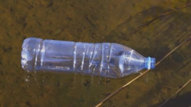 Dalgalı suda süzülen plastik şişe
