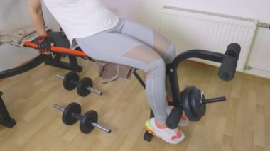  Kadın fitness tezgahı bacak kasları için egzersiz yapıyor