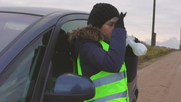 겨울에 도로에서 자동차 근처에 봉지에 숨을들이 마시는 — 비디오