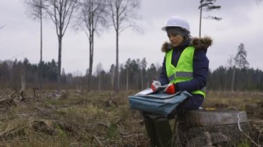 Hasardan sonra ormanı inceleyen kadın mühendis.