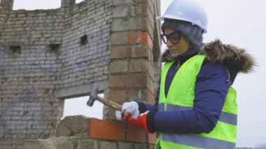 Kadın inşaat mühendisi somut örnekler almak için çekiç kullanıyor