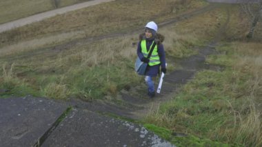 Kadın inşaat mühendisi dik bir şekilde dışarı çıkıyor.