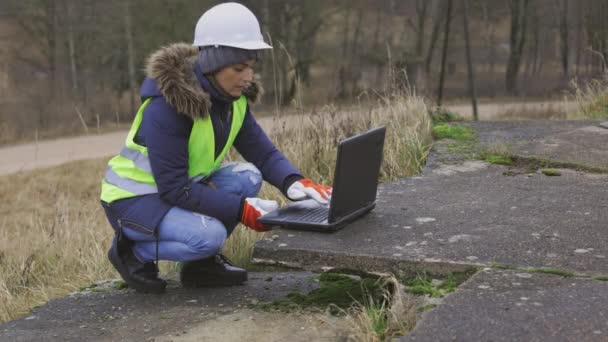 Çatlak Beton Levhalarda Dizüstü Bilgisayar Kullanan Kadın Inşaat Mühendisi — Stok video