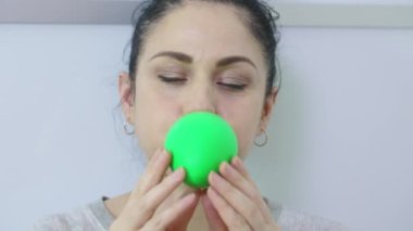 Kadın yeşil balon şişirmeye başladı