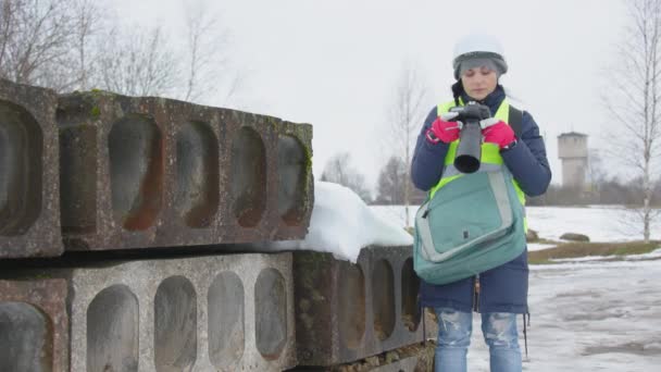 Женщина Инженер Фотографирует Камеру Рядом Бетонными Блоками — стоковое видео
