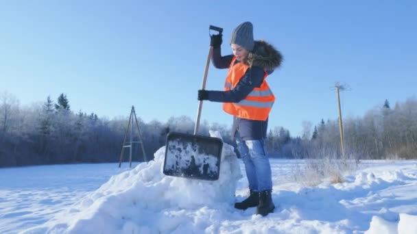 女看门人拿着雪铲碾碎雪堆 — 图库视频影像