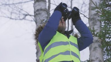 Kadın kuş gözlemi için dürbün kullanıyor.