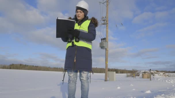 Žena Elektrotechnik Psaní Použití Dalekohledu Blízkosti Vysokonapěťového Vedení — Stock video