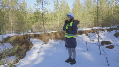 Ormanda akıllı telefondan konuşan kadın bilim adamı.