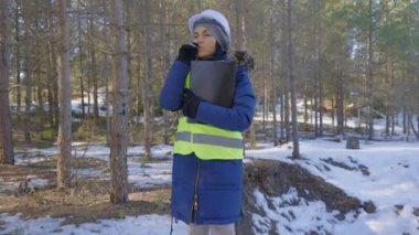 Kadın bilim adamı kış ormanında sigara içiyor