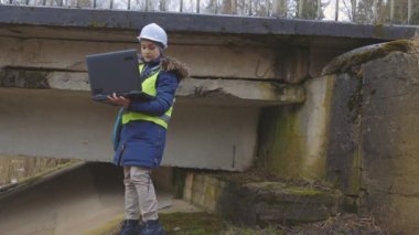  Hasarlı köprüyü inceleyen kadın müteahhit portresi