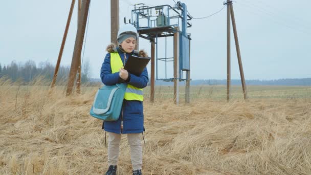 Kvinna Elektrisk Ingenjör Undersöker Kraftledning — Stockvideo