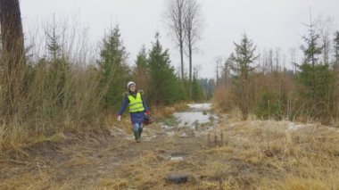 Ormanda yürüyen testereli bir kadın.