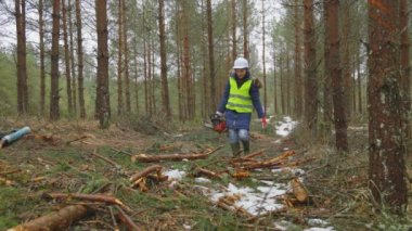Kesme alanında elektrikli testereli kadın.