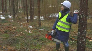 Mutlu kadın orman işçisi baş parmağını gösteriyor.