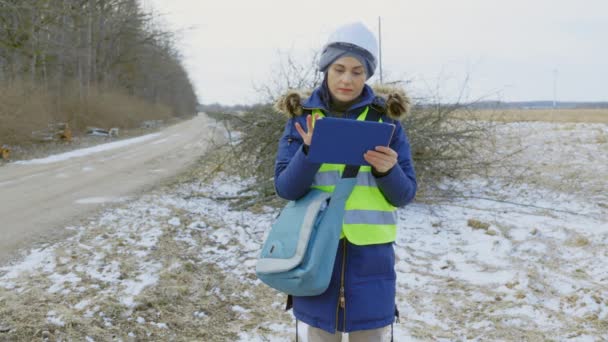 道路の近くに落ちた枝を検査する女性技術者 — ストック動画
