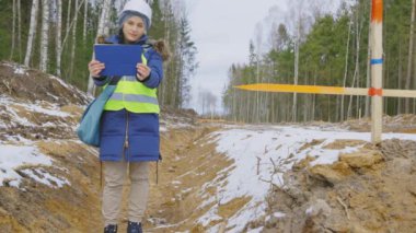 Kadın mimar yol inşaatını filme alıyor.
