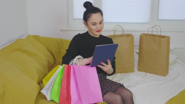 Kvinna Shopping Online Innehav Tablett Med Färgglada Påsar — Stockvideo