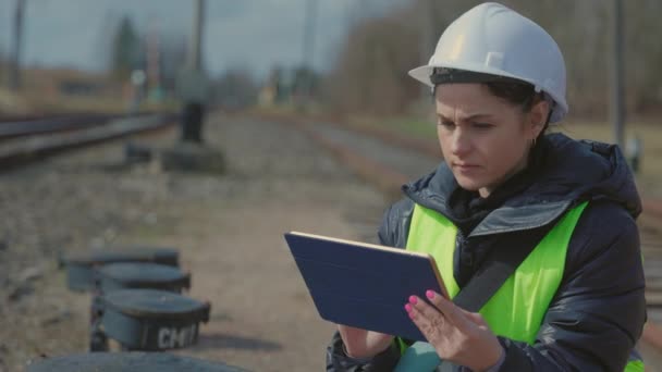 Kvinna Undersöker Järnvägen Nära Stationen — Stockvideo