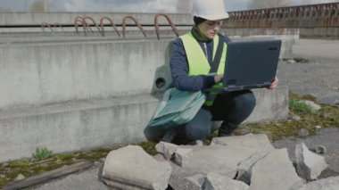 İnşaat alanında dizüstü bilgisayar kullanan kadın mühendis